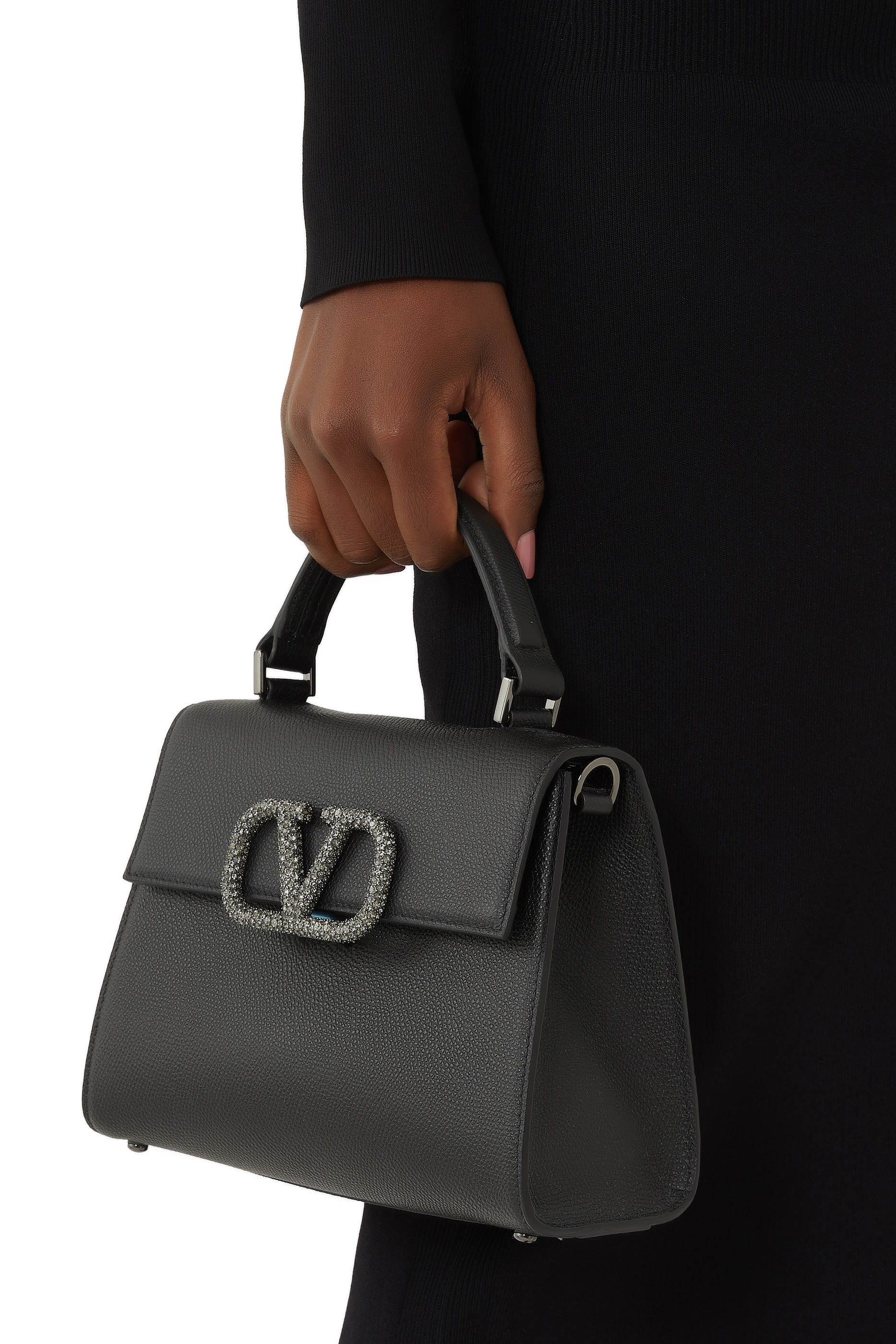 حقيبة صغيرة بيد علوية وشعار الماركة